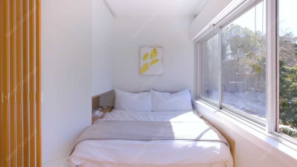 A bed with a window and a painting on the wall