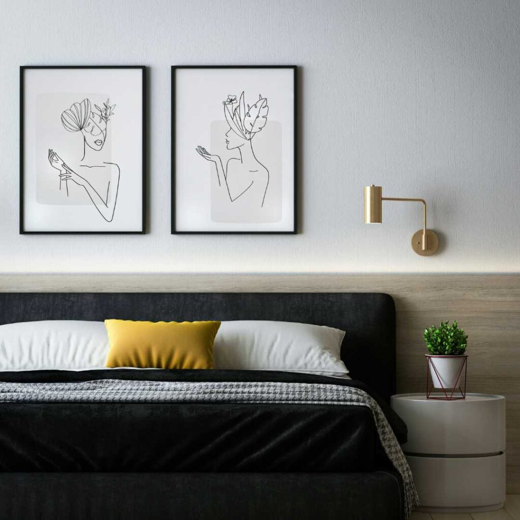 A bedroom with a bed and artworks