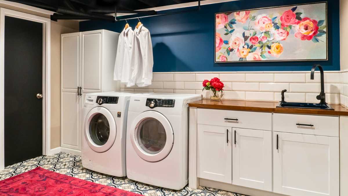 a small laundry room with white cabinets