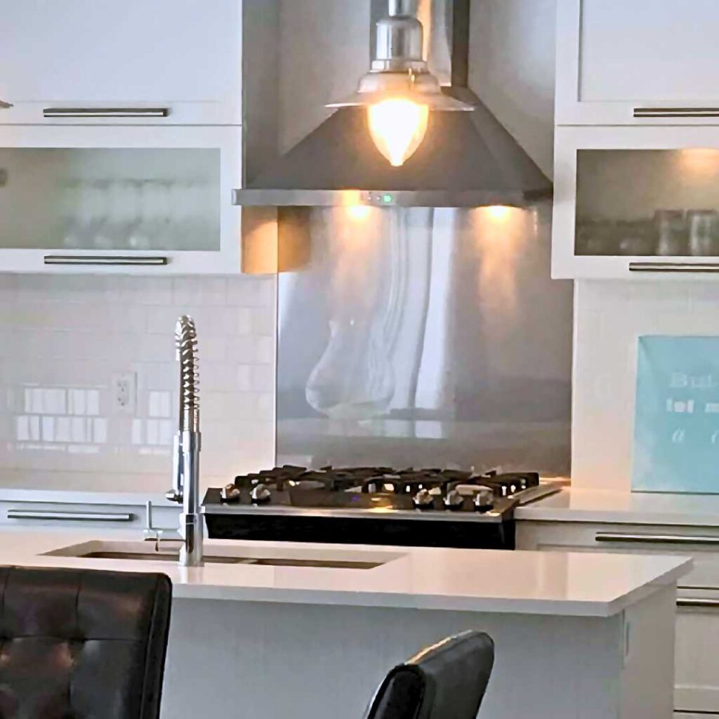 a kitchen with a stainless steel stovetop backsplash