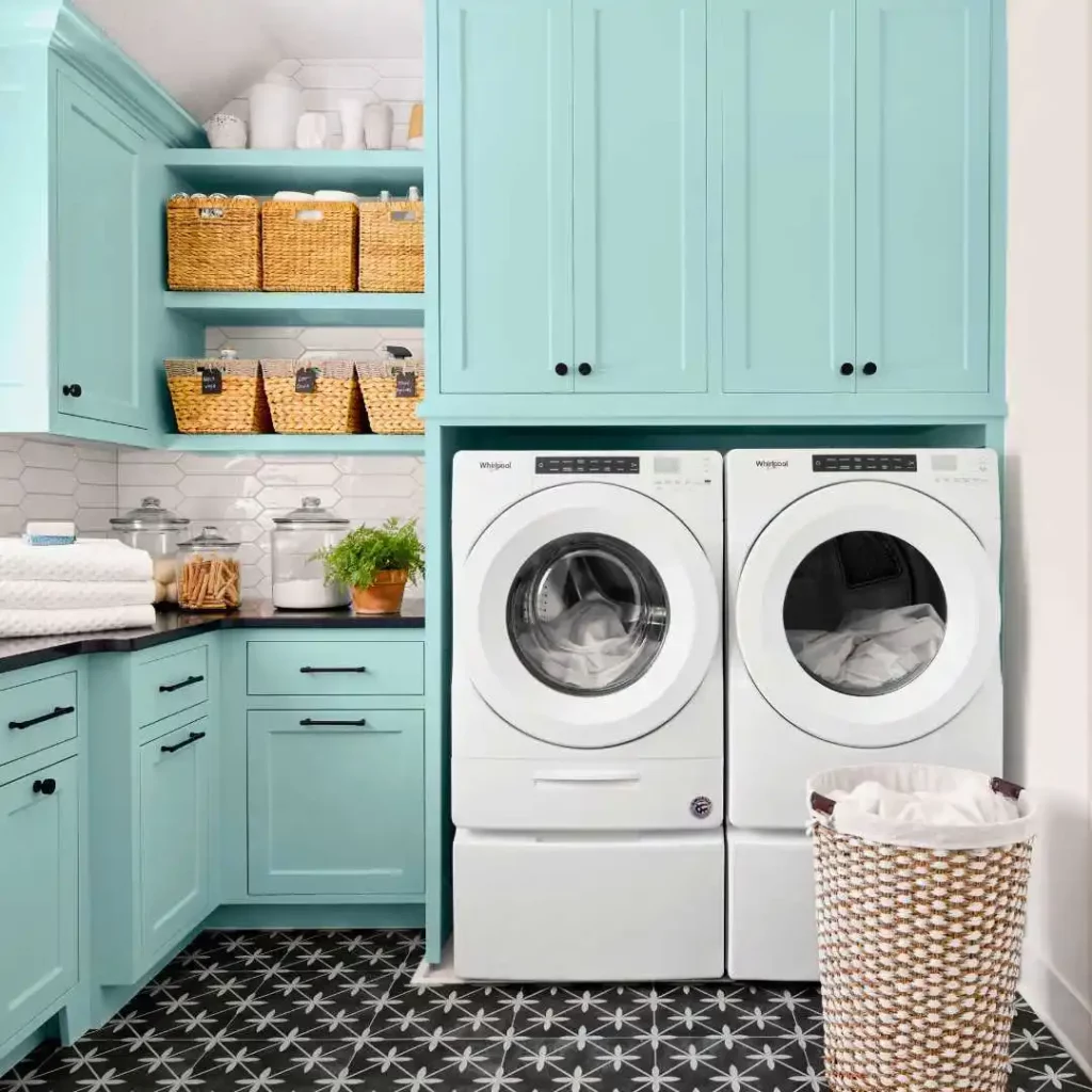 small laundry room with green cabinets