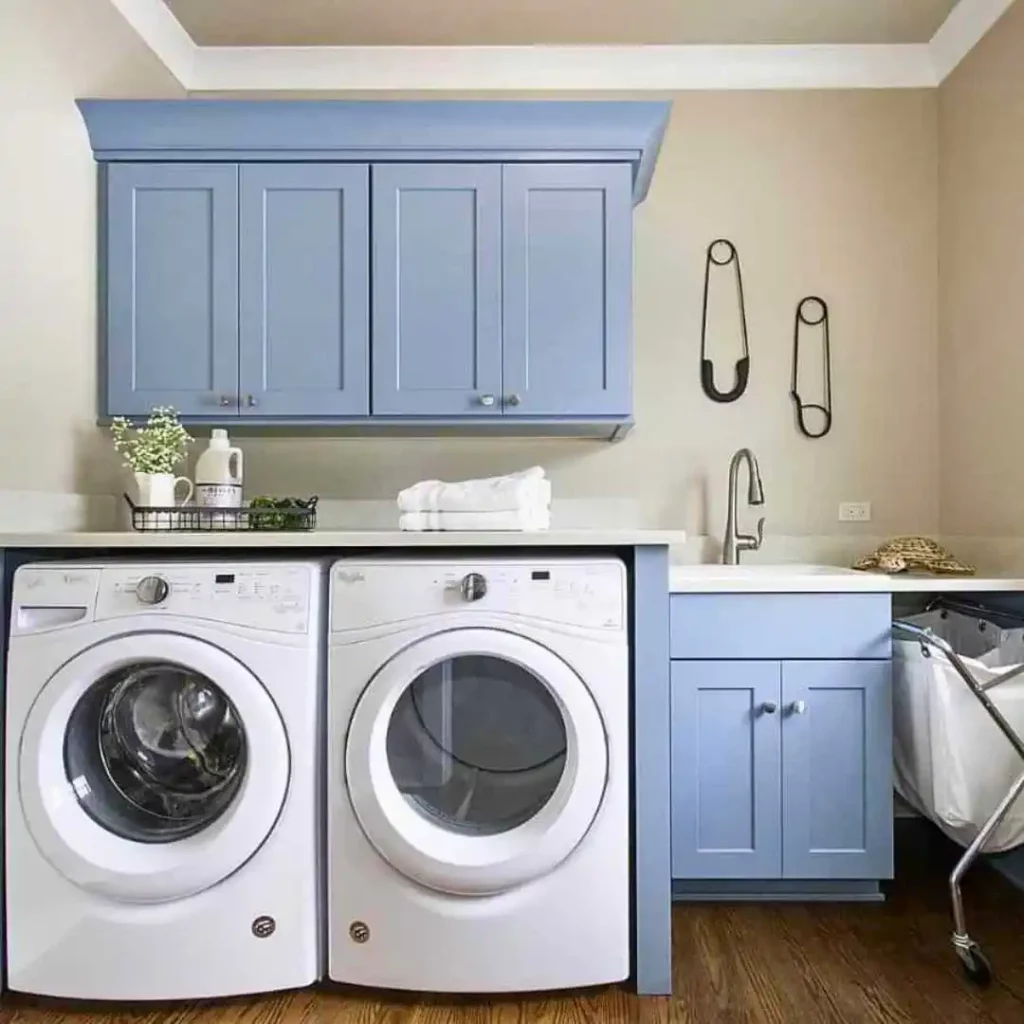 small laundry room with blue cabinets