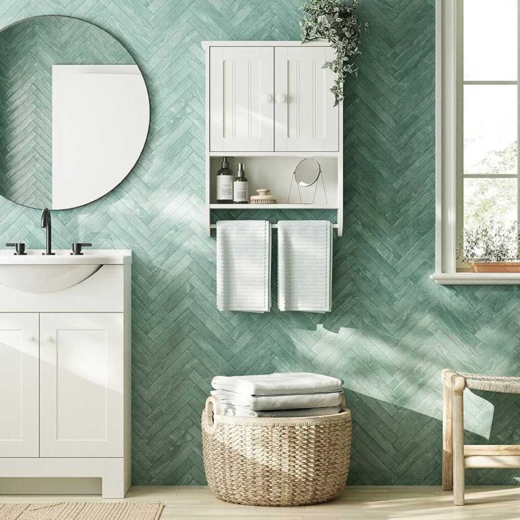 a white bathroom cabinet and a white vanity with mirror on green walled bathroom