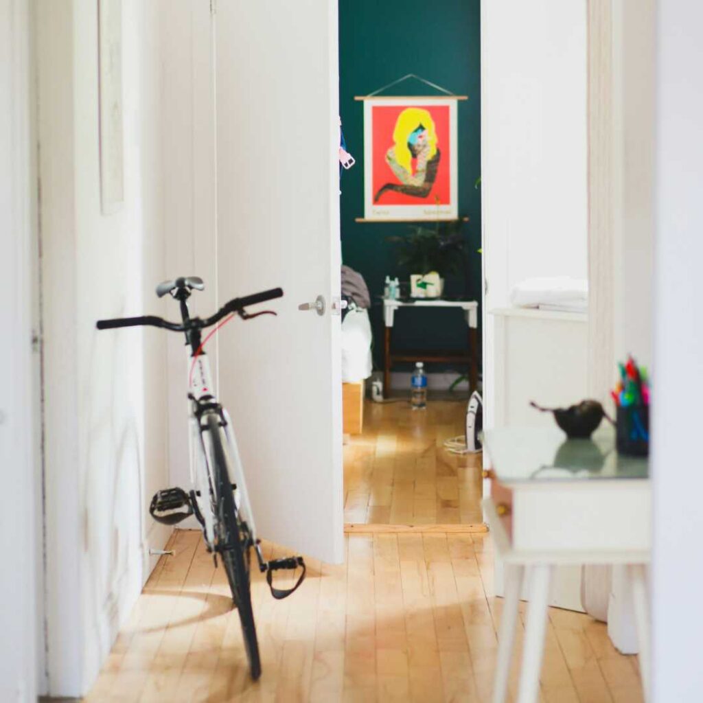 A bicycle in a white hallway